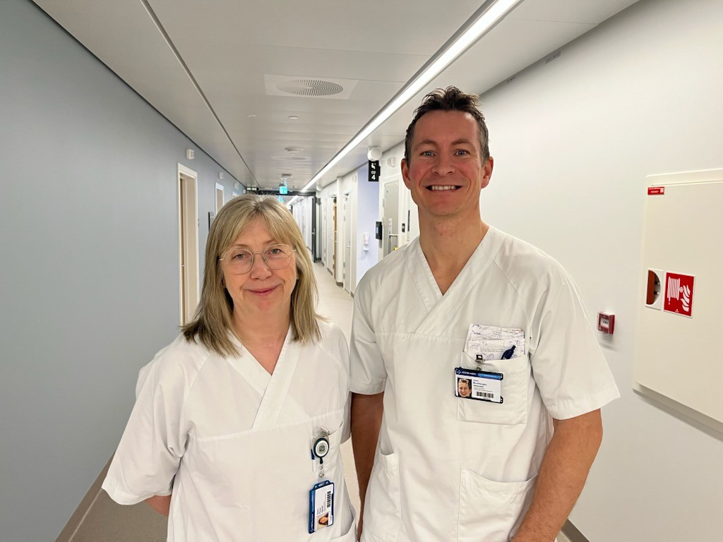 Bildet viser Karin Pleym som er førsteforfatter og John Munkhaugen som er sisteforfatter av den oppsiktsvekkende røykesluttstudien. De er kledd i hvitt og står i en sykehuskorridor.
