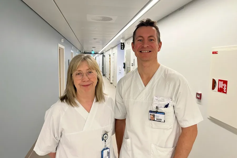 Bildet viser Karin Pleym som er førsteforfatter og John Munkhaugen som er sisteforfatter av den oppsiktsvekkende røykesluttstudien. De er kledd i hvitt og står i en sykehuskorridor.