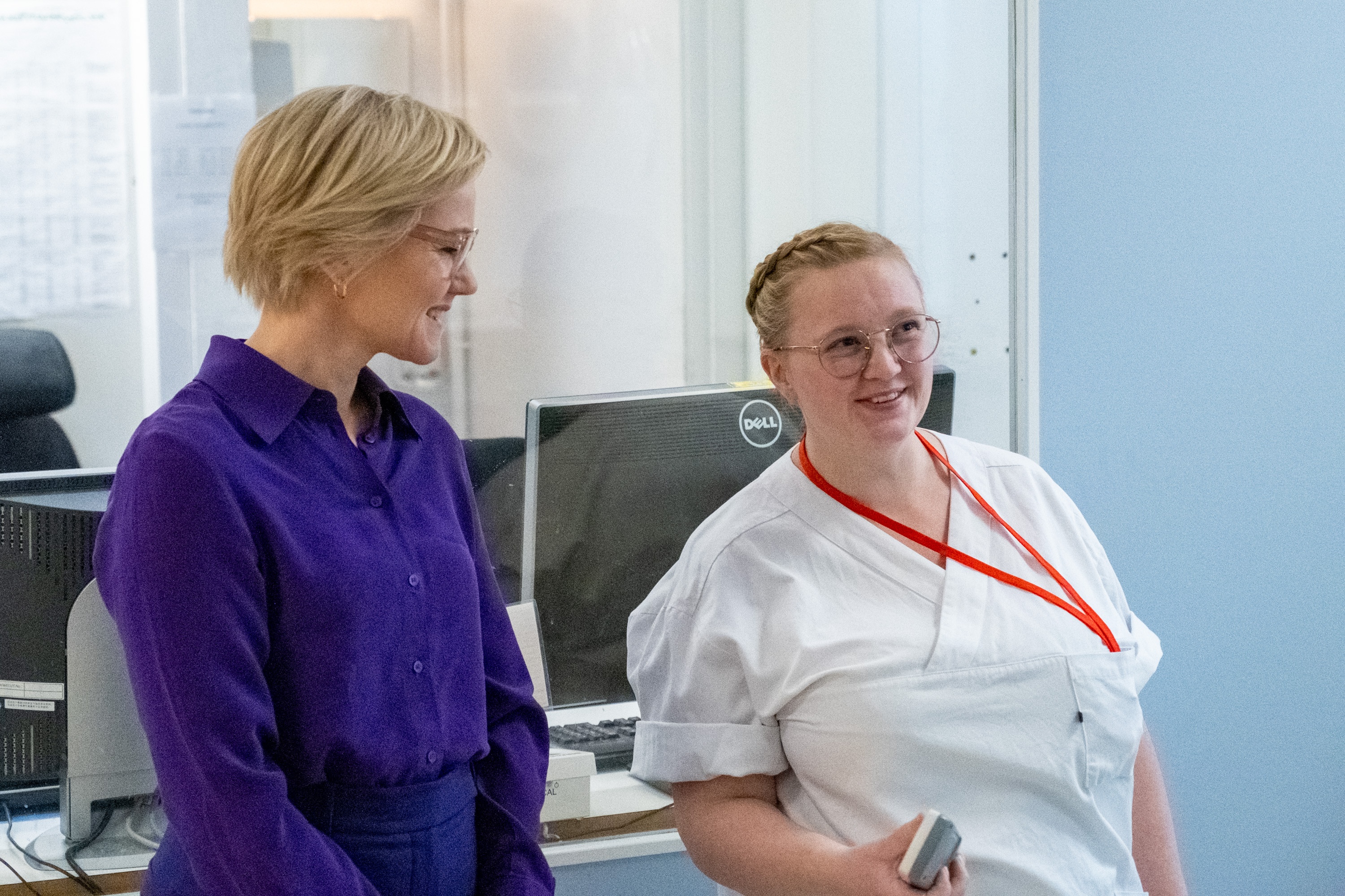 En kvinne står og prater med en sykepleier