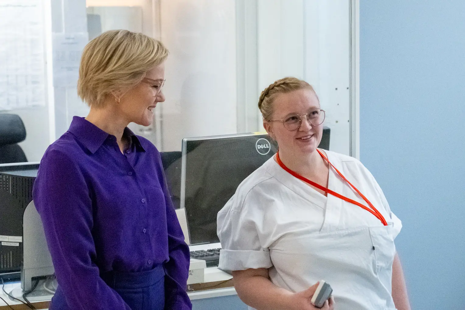 En kvinne står og prater med en sykepleier