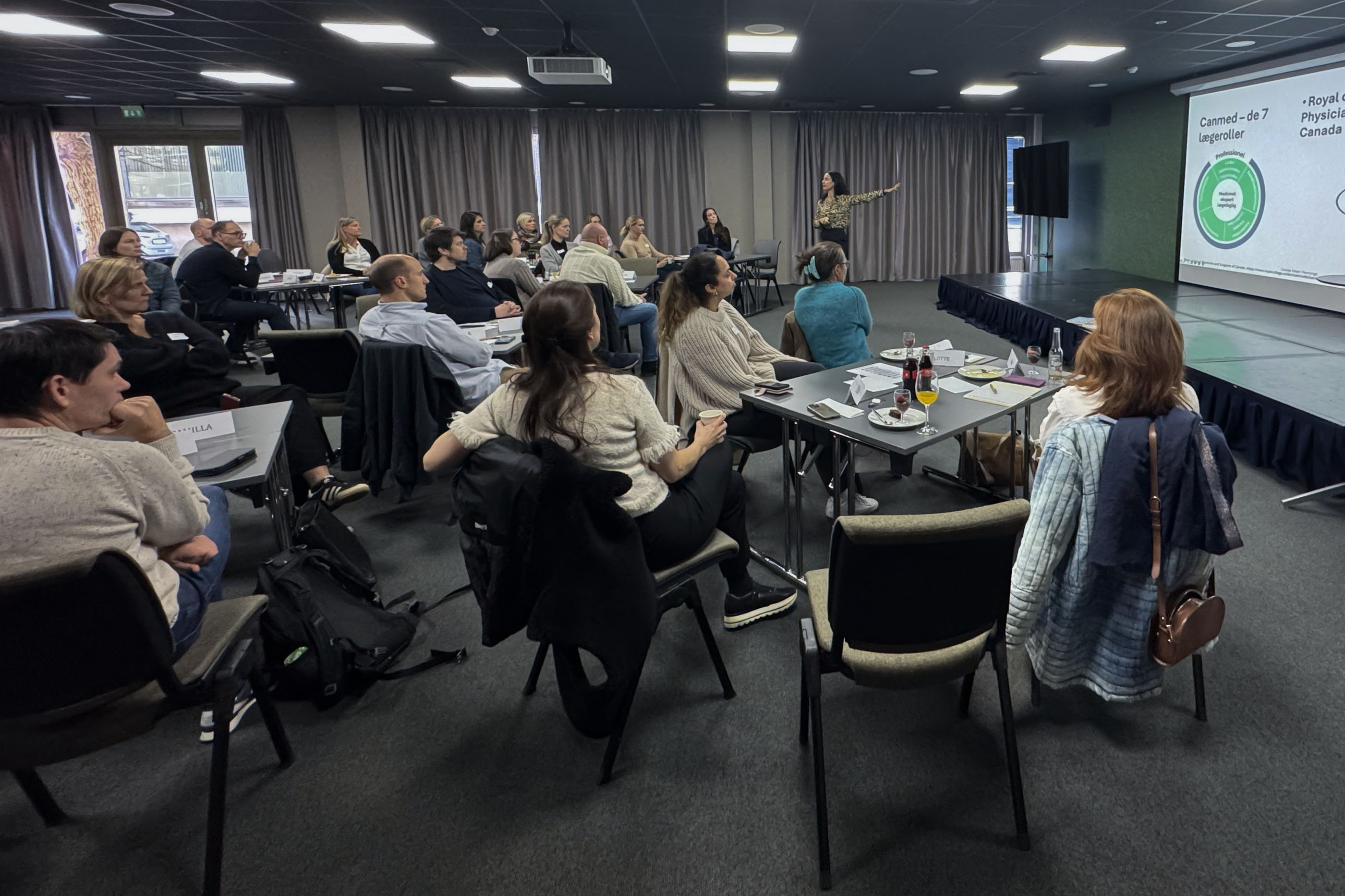 En gruppe mennesker som sitter ved bord