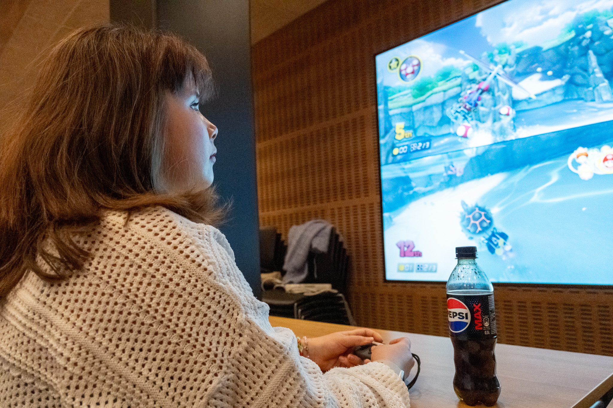 En person som sitter ved et bord og ser på TV