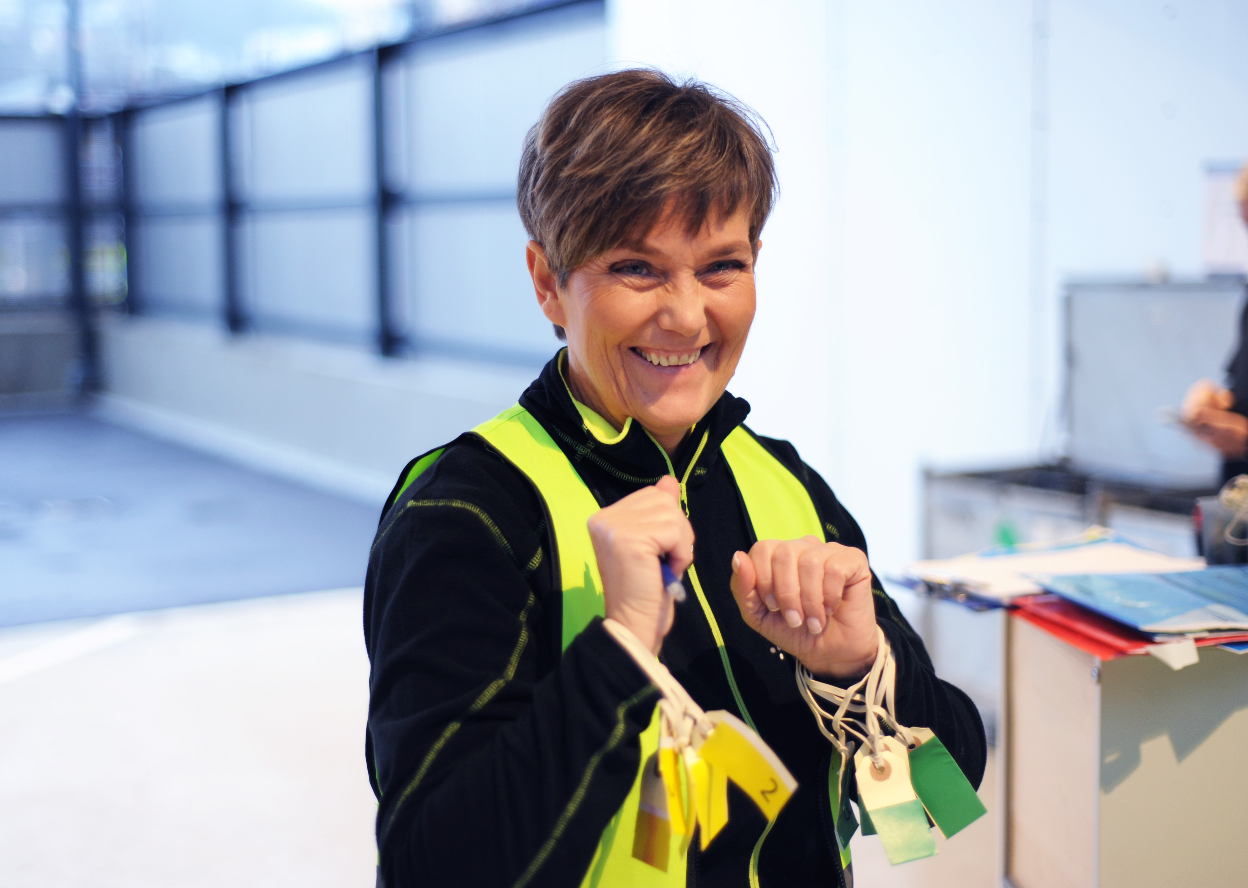 Person med gul vest holder flere triage-merker i hendene under øvelse.