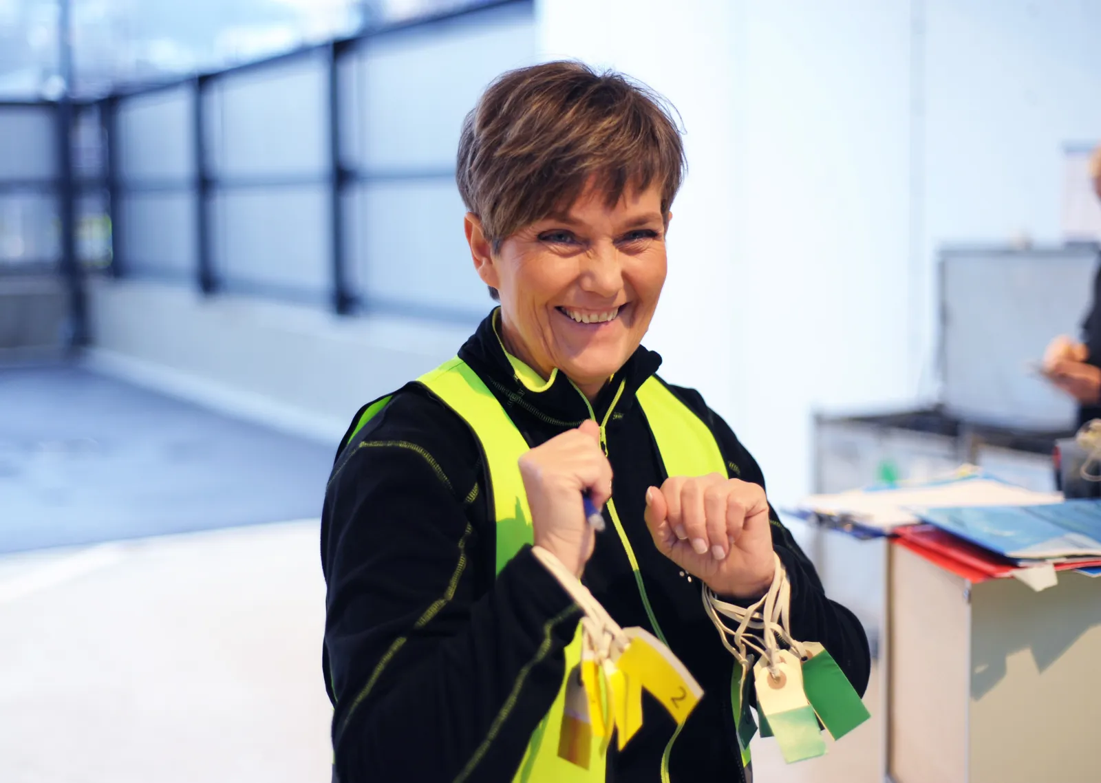 Person med gul vest holder flere triage-merker i hendene under øvelse.