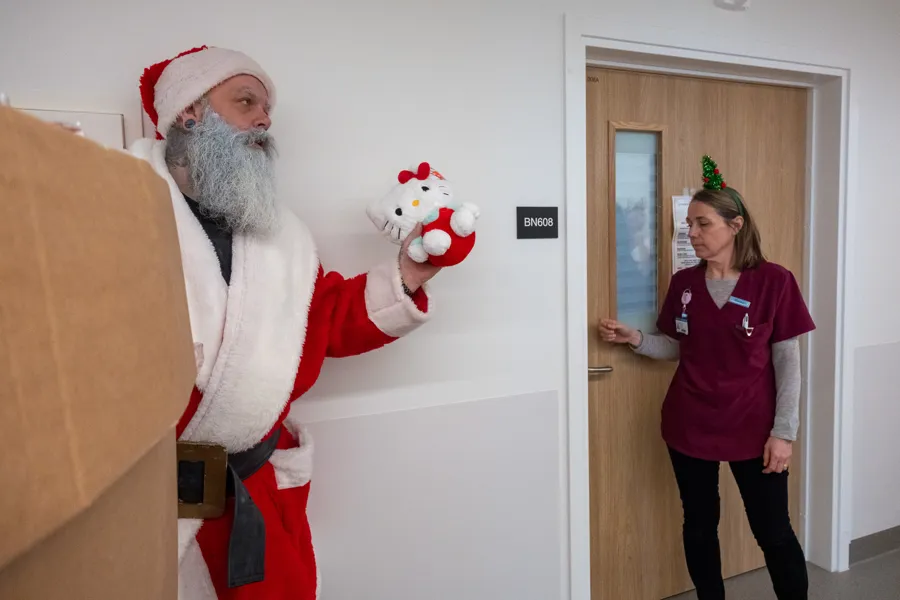 En mann i julenissedrakt og en kvinne i rosa skjorte