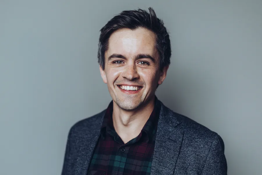 En mann som smiler til kameraet